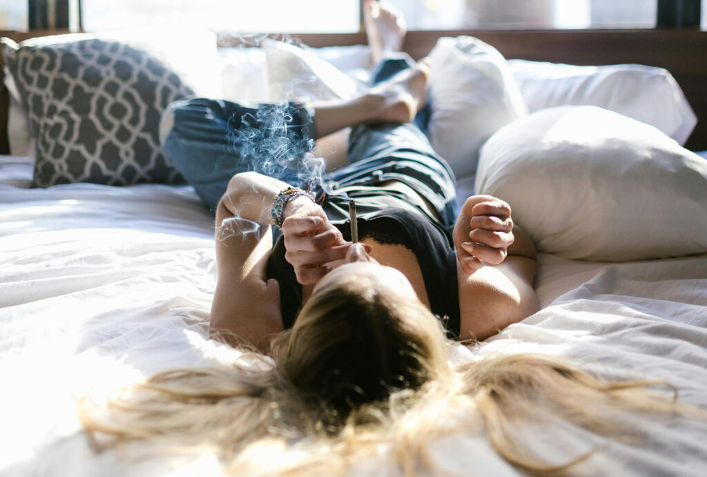 Adult lady enjoying a smoke on a bed on 4/20