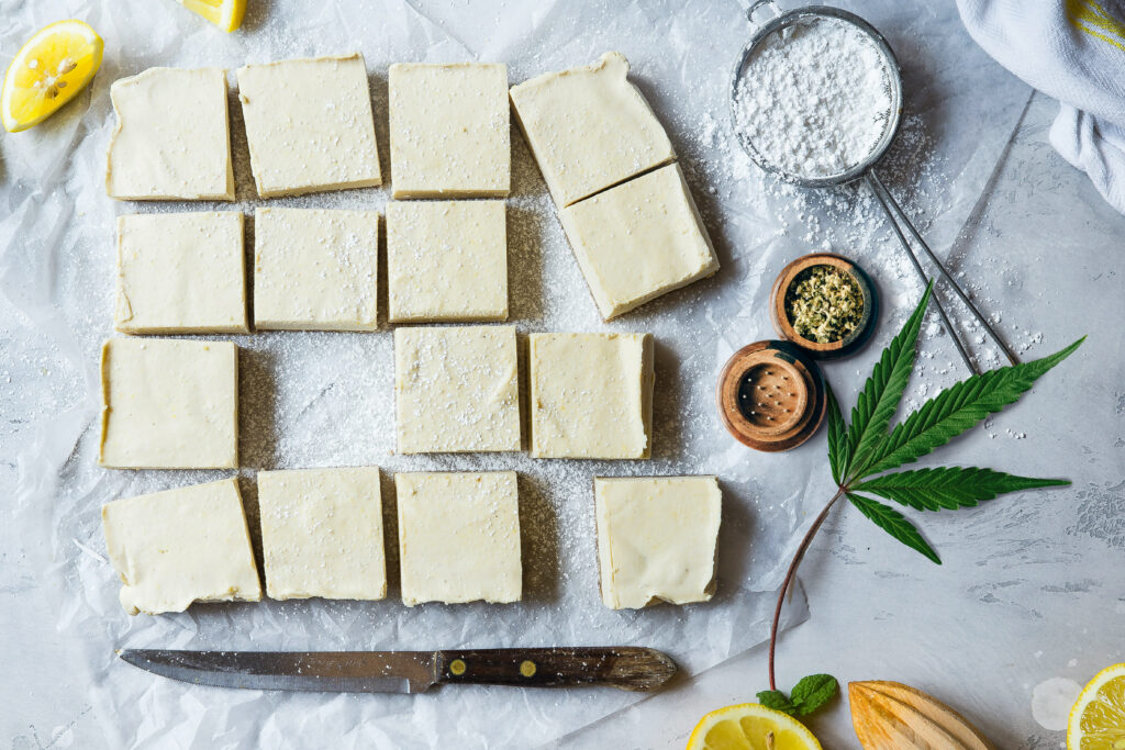 Cannabis Edibles on stone background with grinder