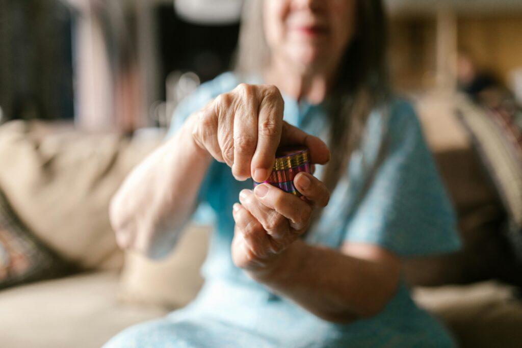 Woman holding out a cannabis flower grinder