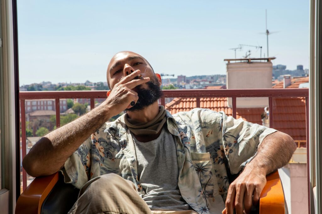 A man smoking a joint on a patio in the summer!