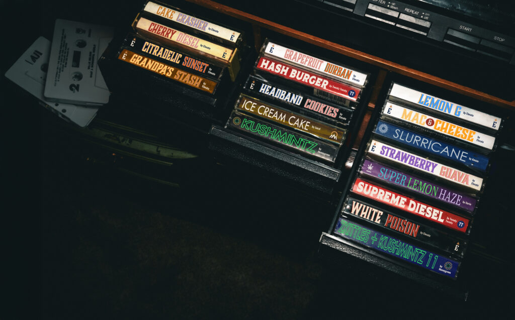 Above shot of tape deck with colorful tapes with weed strain names.