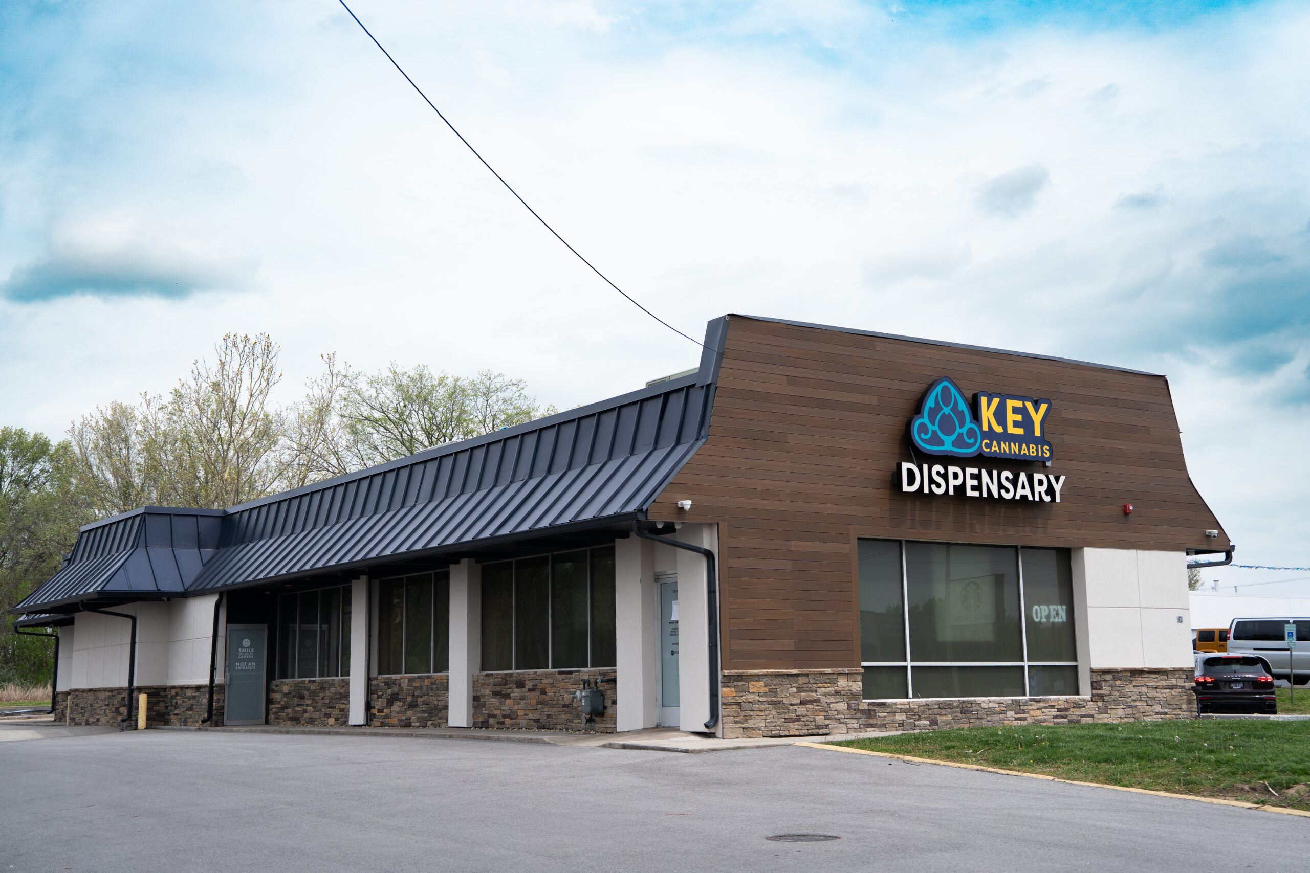 Key Cannabis Store exterior with blue sky and trees in background in Carbondale Illinois.