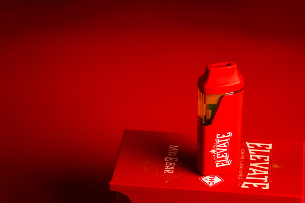 Red Min-E-Bar vape on a red packaged, against a red background