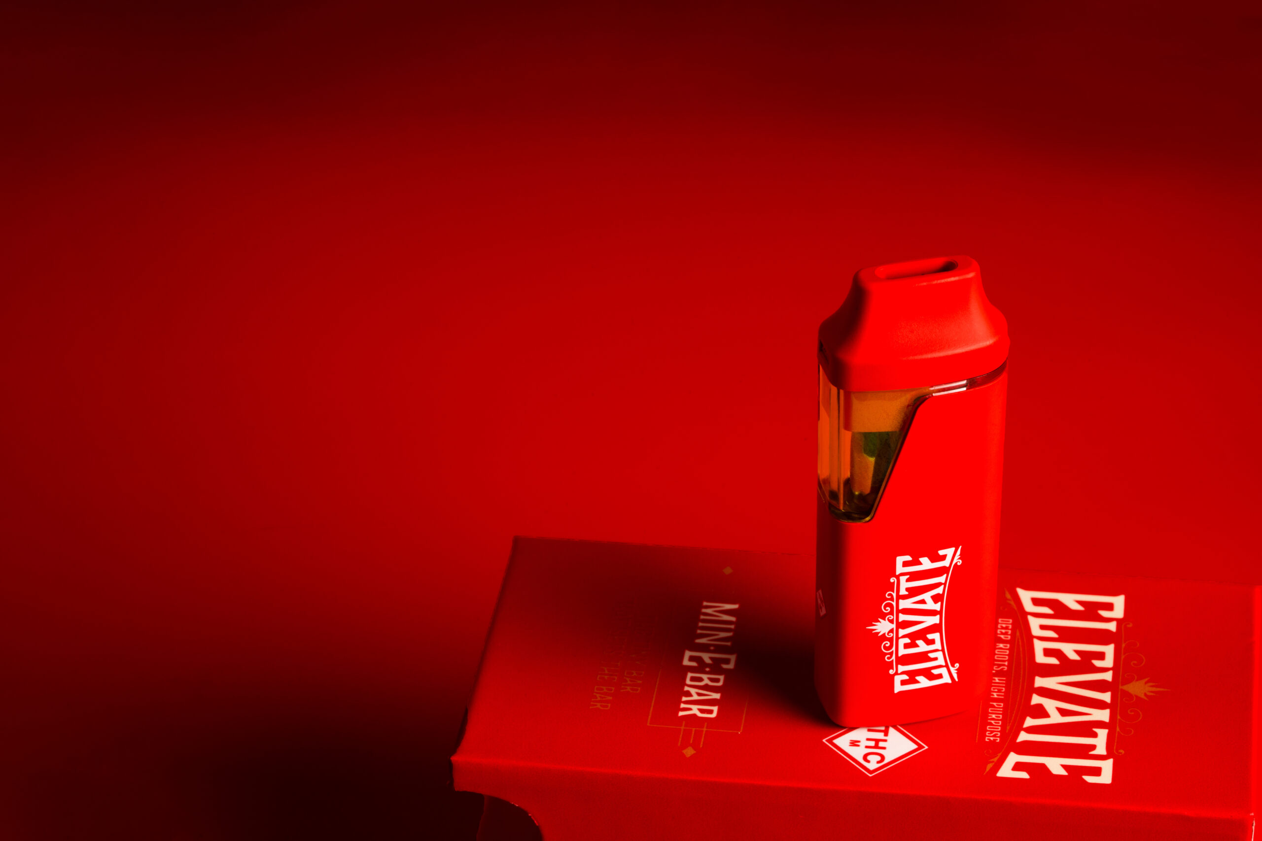 Red Min-E-Bar vape on a red packaged, against a red background