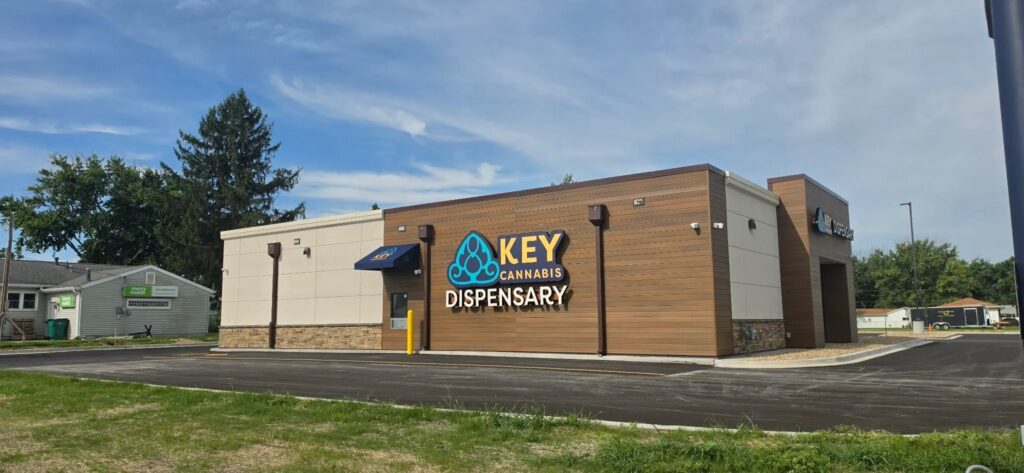 exterior of Key Cannabis Dispensary buildling surrounded by a parking lot and green grass